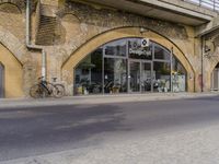 a street with two buildings and graffiti on the walls with old doors and windows that are leaning against each other