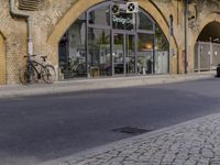 a street with two buildings and graffiti on the walls with old doors and windows that are leaning against each other