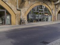 a street with two buildings and graffiti on the walls with old doors and windows that are leaning against each other