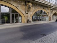 a street with two buildings and graffiti on the walls with old doors and windows that are leaning against each other