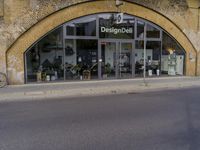 a street with two buildings and graffiti on the walls with old doors and windows that are leaning against each other