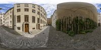 a street view with a circular shaped building in the middle of it and a tree in the background