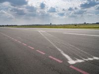 an airport runway with white clouds and a blue sky background that appears to be about 15 degrees empty