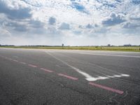 an airport runway with white clouds and a blue sky background that appears to be about 15 degrees empty