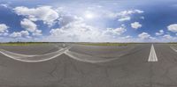 a view of a very wide empty road with a cloudy sky background and white clouds