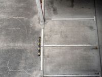 an overhead view shows an empty parking garage in a warehouse building, with yellow safety markers on the floor