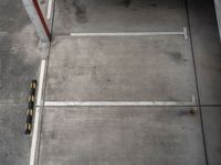 an overhead view shows an empty parking garage in a warehouse building, with yellow safety markers on the floor