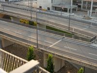 a freeway with many lanes, several buildings and a traffic light over it on the other side of a street