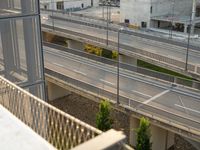 a freeway with many lanes, several buildings and a traffic light over it on the other side of a street