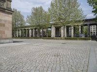 the large courtyard is made of stone bricks and brick pillars, with the statue in a courtyard on the far side