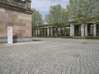 the large courtyard is made of stone bricks and brick pillars, with the statue in a courtyard on the far side