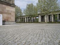 the large courtyard is made of stone bricks and brick pillars, with the statue in a courtyard on the far side