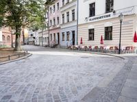 a paved area with a stone paved sidewalk and patio furniture sets on the corner of an intersection