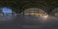 fish eye view from the bottom of a train station with two trains underneath, and a clock tower