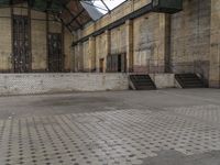 a train station has many steps leading to it and is empty except for people to walk