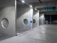 there is an empty underground parking lot at night time, with signs and the name