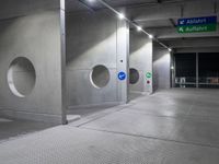 there is an empty underground parking lot at night time, with signs and the name