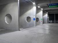 there is an empty underground parking lot at night time, with signs and the name