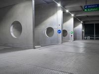 there is an empty underground parking lot at night time, with signs and the name