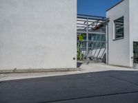 a side view of an industrial building with bicycle racks and bicycles parked by it's doors