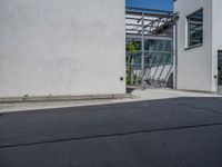 a side view of an industrial building with bicycle racks and bicycles parked by it's doors