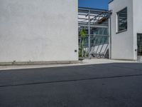 a side view of an industrial building with bicycle racks and bicycles parked by it's doors