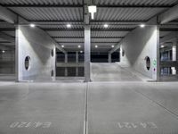 an empty parking garage with large doors and graffiti on the floor, near a closed door