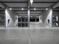 an empty parking garage with large doors and graffiti on the floor, near a closed door