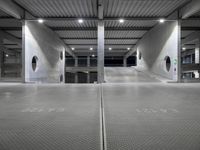 an empty parking garage with large doors and graffiti on the floor, near a closed door