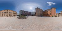 a very large brick building in a large circle next to other brick buildings and people