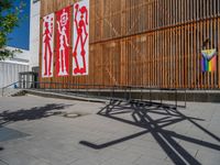 a group of people riding skateboards near wooden panels and stairss with artwork on them