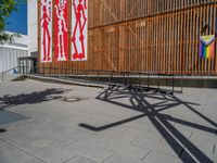 a group of people riding skateboards near wooden panels and stairss with artwork on them