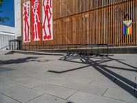 a group of people riding skateboards near wooden panels and stairss with artwork on them