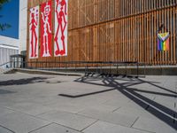 a group of people riding skateboards near wooden panels and stairss with artwork on them