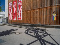 a group of people riding skateboards near wooden panels and stairss with artwork on them