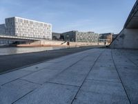 a skateboard sits outside a concrete structure that is next to a street area with a bench