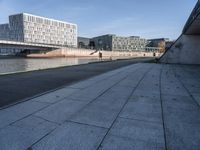 a skateboard sits outside a concrete structure that is next to a street area with a bench