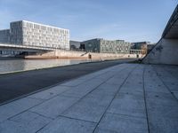 a skateboard sits outside a concrete structure that is next to a street area with a bench