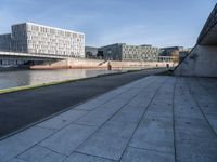 a skateboard sits outside a concrete structure that is next to a street area with a bench