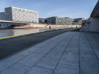 a skateboard sits outside a concrete structure that is next to a street area with a bench