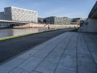 a skateboard sits outside a concrete structure that is next to a street area with a bench