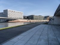 a skateboard sits outside a concrete structure that is next to a street area with a bench