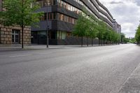 a street has been paved with small bushes, trees, and buildings in front of a building