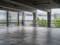 an empty space with floor to ceiling windows that have plants on it and trees in the background