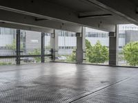 an empty space with floor to ceiling windows that have plants on it and trees in the background