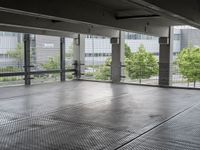 an empty space with floor to ceiling windows that have plants on it and trees in the background