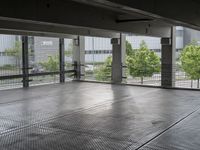 an empty space with floor to ceiling windows that have plants on it and trees in the background