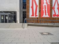 a group of people riding skateboards near wooden panels and stairss with artwork on them