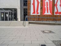 a group of people riding skateboards near wooden panels and stairss with artwork on them