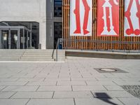 a group of people riding skateboards near wooden panels and stairss with artwork on them